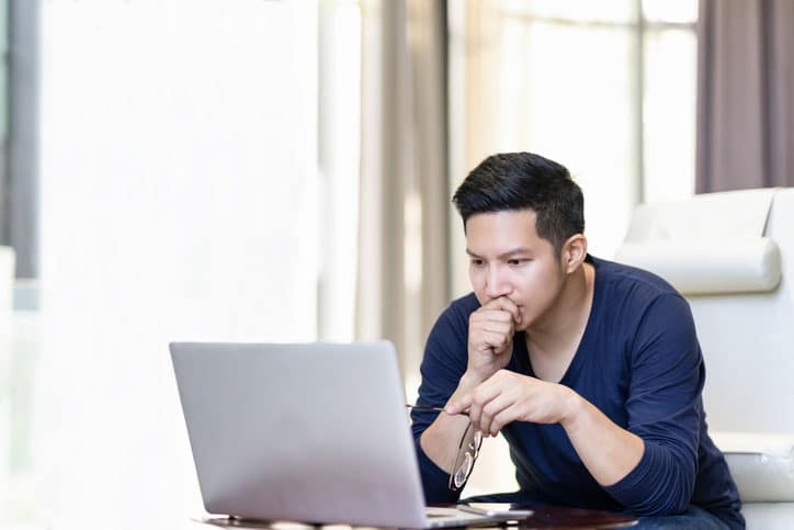 Asian Man Looking At Laptop Closely